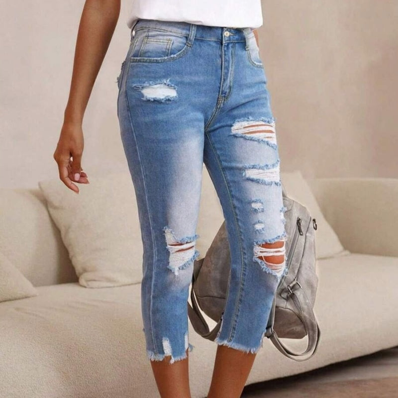 Gewassen en gescheurde damesjeans met onbewerkte zoom