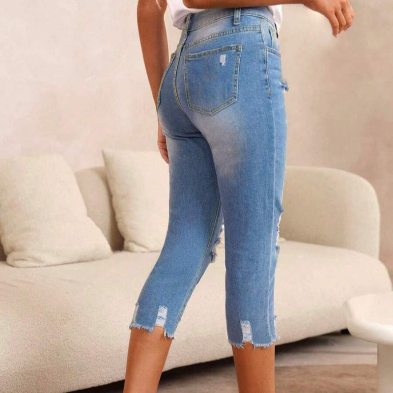 Gewassen en gescheurde damesjeans met onbewerkte zoom