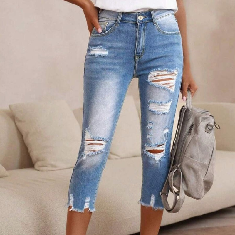 Gewassen en gescheurde damesjeans met onbewerkte zoom
