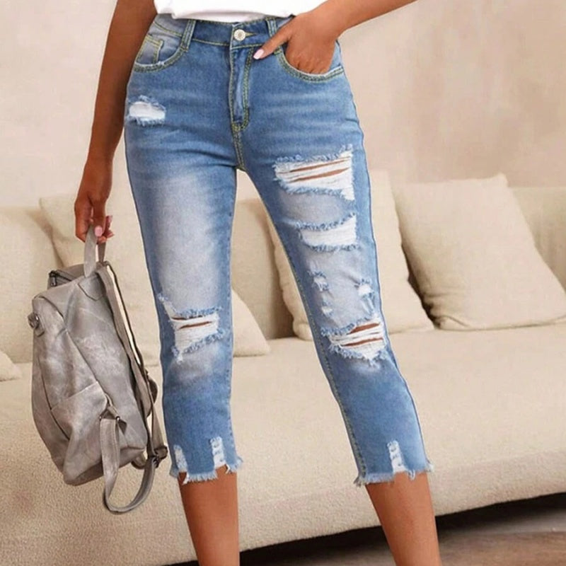 Gewassen en gescheurde damesjeans met onbewerkte zoom